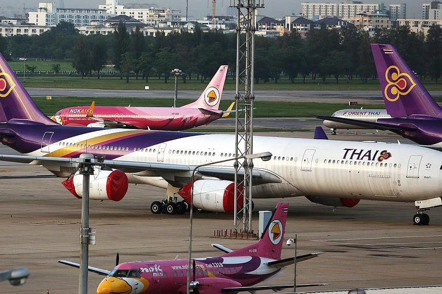 Thai Airways will reduce its workforce by around 5,000, or around 20 percent, over several years through attrition, the Bangkok Post newspaper reported on Wednesday, citing the transport minister.&nbsp;-- PHOTO:&nbsp;BLOOMBERG
