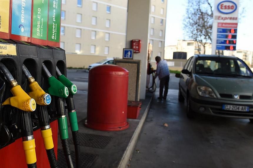 A customer filling up his fuel tank at a petrol station in Marseille, south-eastern France, on Dec 26, 2014. -- PHOTO: AFP