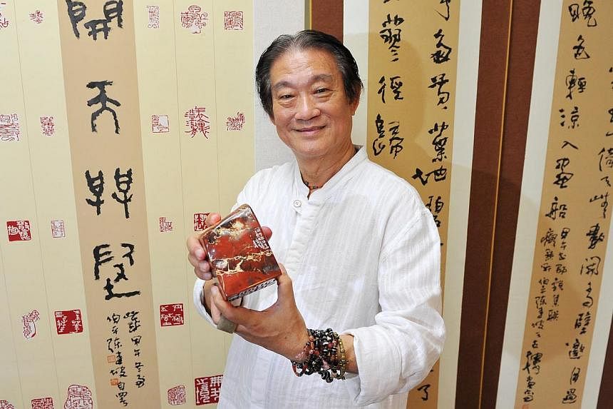 Singapore Chinese ink painter, calligrapher and seal carver Tan Kian Por is holding an exhibition which showcases seals carved on stones from Kluang, Malaysia. -- PHOTO: LIM YAOHUI FOR THE STRAITS TIMES