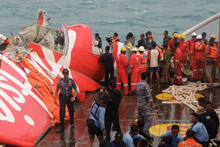 In this Jan 10, 2015 photo, wreckage from AirAsia flight QZ8501 is lifted into a ship at sea south of Borneo island. -- PHOTO: AFP