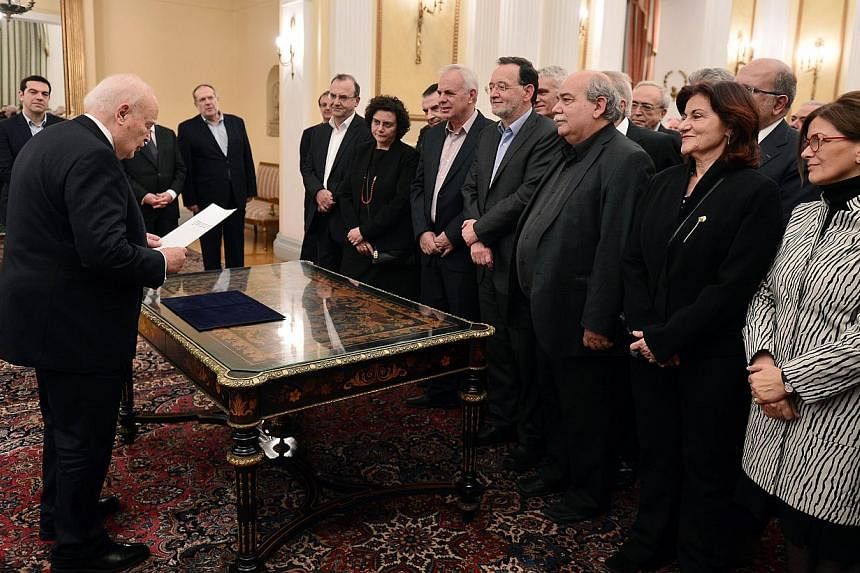 The newly formed government of Prime Minister Alexis Tsipras taking the civil oath in the presence of the Greek President Karolos Papoulias at the presidental palace in Athens on Jan 27, 2015. -- PHOTO: AFP