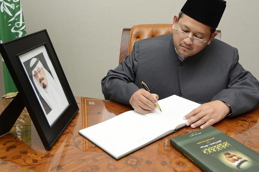 Dr&nbsp;Mohamed Fatris Bakaram, the Mufti of Singapore, writing a message of condolence for the late King Abdullah of Saudi Arabia. -- PHOTO: MUIS