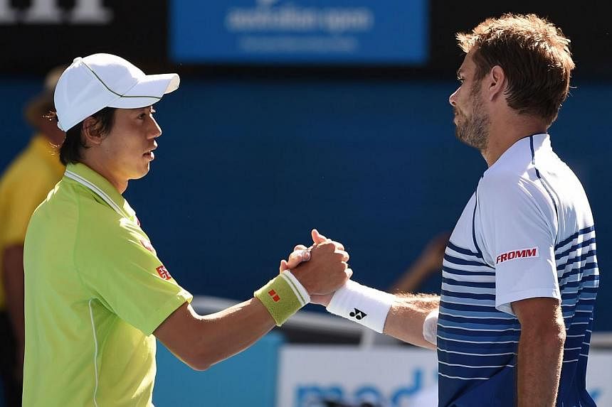 Switzerland's Stanislas Wawrinka (right) shakes hands as he celebrates after victory in his men's singles match against Japan's Kei Nishikori (left) on day ten of the 2015 Australian Open tennis tournament in Melbourne on Jan 28, 2015. -- PHOTO: AFP