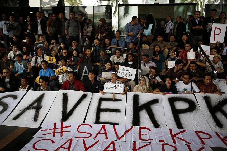 Indonesian anti-corruption activists hold banners supporting the Corruption Eradiction Commission (KPK) during a protest at the KPK office in Jakarta, Indonesia, on Jan 23, 2015. -- PHOTO: EPA