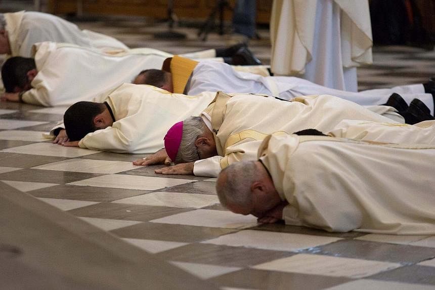 Archbishop of Granada Francisco Javier Martinez and priests prostrate in front of the altar to seek pardon for sexual abuse in the Church at the cathedral in Granada, southern Spain on November 23, 2014. PHOTO: REUTERS