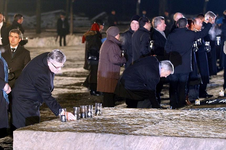 President of Poland Bronislaw Komorowski (right) and his wife Anna Komorowska (left) light candles at the International Monument to the Victims of Fascism at the former Nazi-German concentration and extermination camp KL Auschwitz II-Birkenau as part