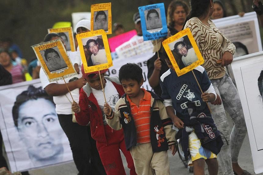 People carrying pictures of some of the 43 students who went missing in September in Mexico during a demonstration in&nbsp;Tixtla, on the outskirts of Chilpancingo, in the Mexican state of Guerrero, on Dec 7, 2014. -- PHOTO: REUTERS