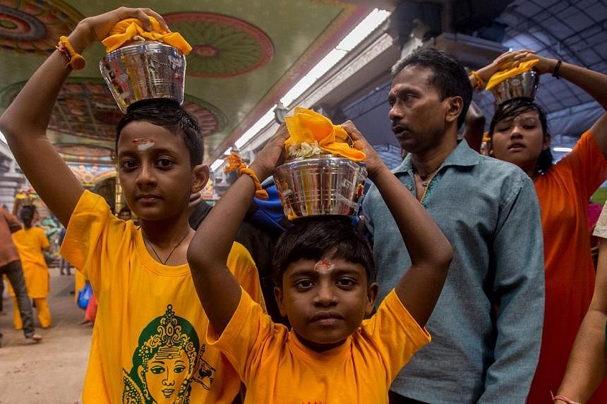 Children carrying palkudam during last year's Thaipusam procession. The annual Thaipusam Festival procession will begin at 12.05am on Feb 3 this year, the Hindu Endowments Board announced on Wednesday. -- PHOTO: TAMIL MURASU FILE&nbsp;