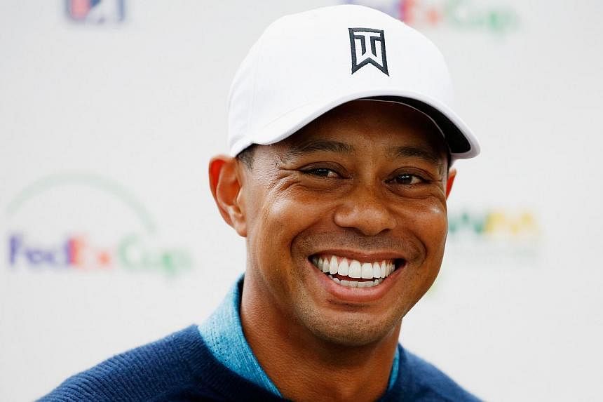 Tiger Woods, who had a front tooth knocked out by a video cameraman last week, displayed a full smile Tuesday (above) after a nine-hole practice round ahead of the Phoenix Open. -- PHOTO: AFP