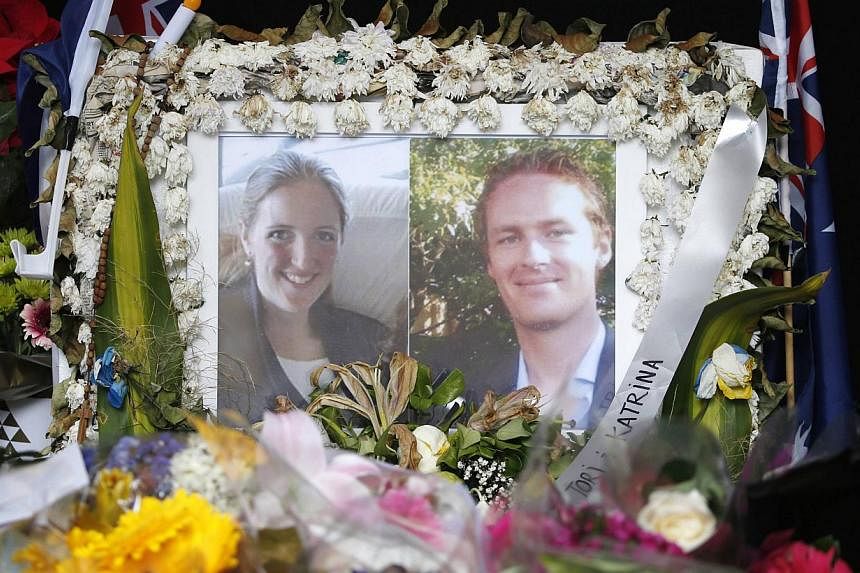 Photographs of Sydney's cafe siege victims, lawyer Katrina Dawson (left) and cafe manager Tori Johnson displayed &nbsp;in a floral tribute near the site of the siege. Ms Dawson was killed by ricochets of a police bullet or bullets, an inquest heard o