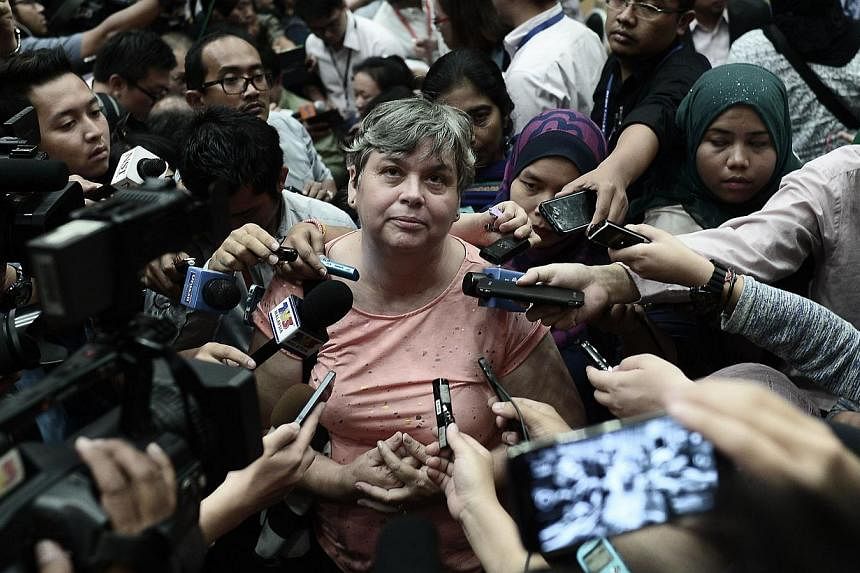 A relative (centre) of a passenger of the missing Malaysia Airlines flight MH370 talking to journalists at a press conference in Putrajaya on Jan 29, 2015. -- PHOTO: AFP
