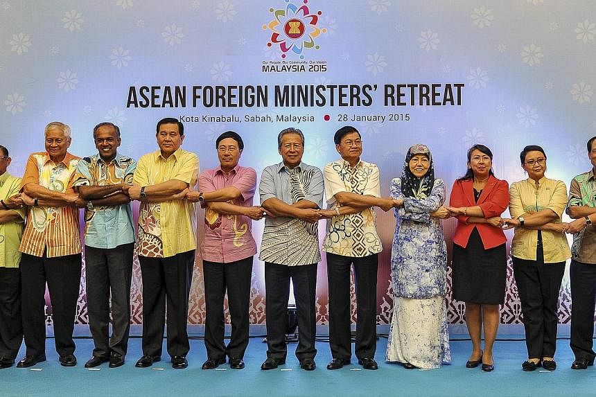 Asean's Foreign Ministers and delegates cross arms and hold hands during the Asean Foreign Ministers Retreat in Kota Kinabalu, Malaysia, on Jan 28, 2015. -- PHOTO: EPA