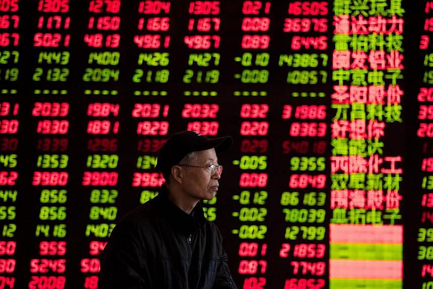An investor looks at stock informations at a trading hall of a securities firm in Shanghai on Jan 28, 2014. -- PHOTO: AFP