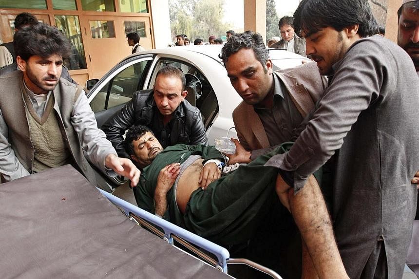 Afghan men carry a wounded man at a hospital in Jalalabad, after a suicide attack which targeted funeral prayers in Laghman province, Jan 29, 2015. -- PHOTO: REUTERS