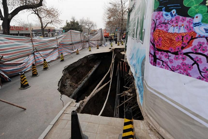 This photo taken on the morning of Saturday, Jan 24, 2015, shows a big hole on a street in Beijing's Xicheng district. The hole has since been filled in with 1,400 cu m of concrete. -- PHOTO: CHINA DAILY/ASIA NEWS NETWORK