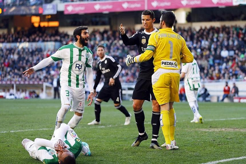 Real Madrid's Cristiano Ronaldo (second right) reacts as Cordoba's Edimar Fraga (bottom) lies on the pitch during their Spanish First Division soccer match at El Arcangel stadium in Cordoba, Jan 24, 2015. -- PHOTO: REUTERS