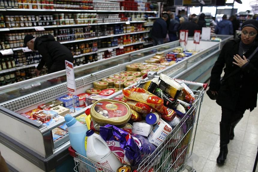 A woman walking near a shopping trolley full of products in a supermarket in Jerusalem, Israel, on Jan 6, 2015. Researchers&nbsp;found 15 chemicals that were significantly associated with earlier menopause and declines in ovarian function, Some of wh