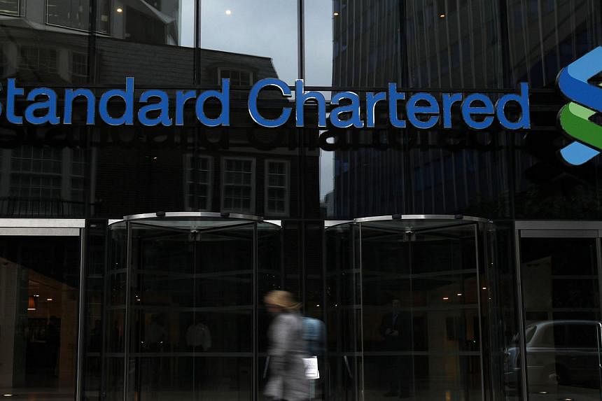 A woman walks past a Standard Chartered bank in London on Oct 13, 2010. Standard Chartered has appointed Aaron Russell-Davison as head, debt capital markets, with immediate effect.&nbsp;-- PHOTO: REUTERS