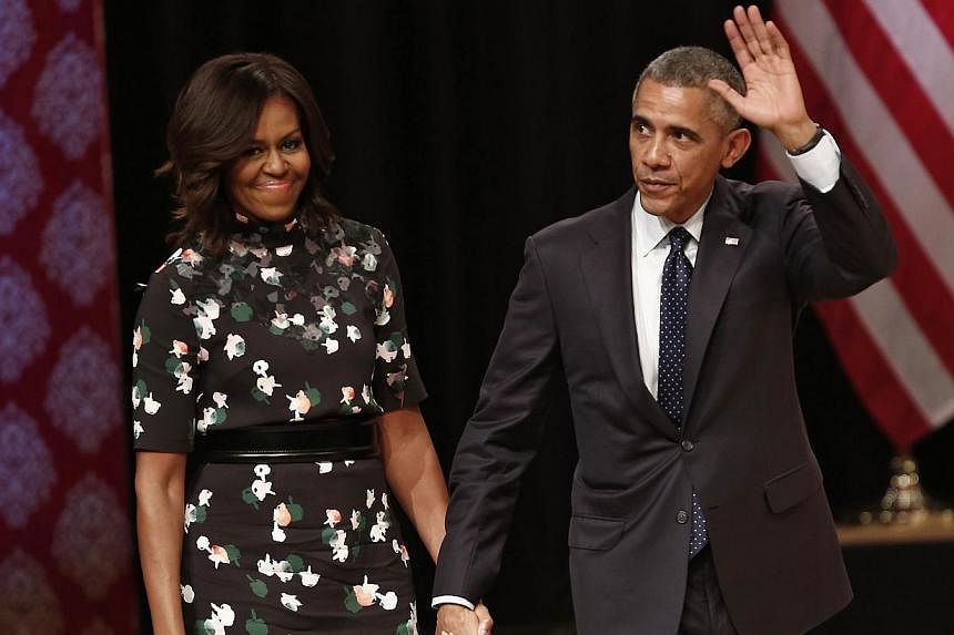 US President Barack Obama waves as he walks with first lady Michelle Obama to greet the audience after he delivered a speech at Siri Fort Auditorium in New Delhi on Jan 27, 2015. -- PHOTO: REUTERS