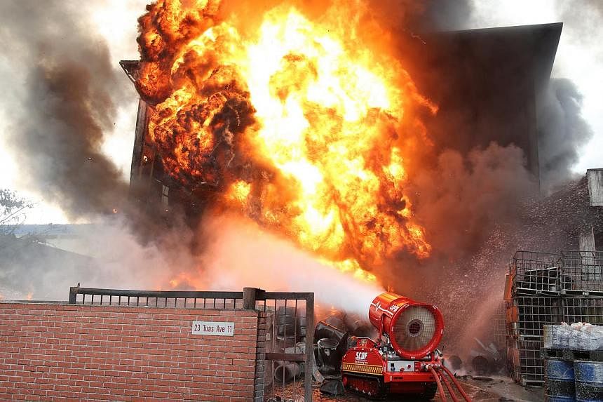 The Singapore Civil Defence Force’s (SCDF) remote-controlled unmanned firefighting machine fighting a blaze at a waste chemical facility in Tuas on April 27, 2014. -- PHOTO: SCDF
