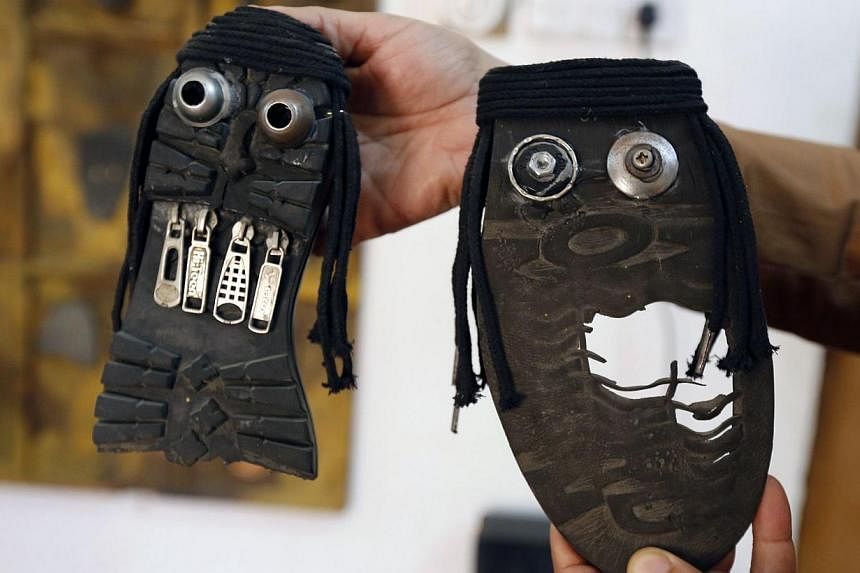 Iraqi artist Akeel Khreef showing some of his art pieces depicting jihadists on the soles of worn-out shoes on Jan 13, 2015 in Baghdad. -- PHOTO: AFP&nbsp;
