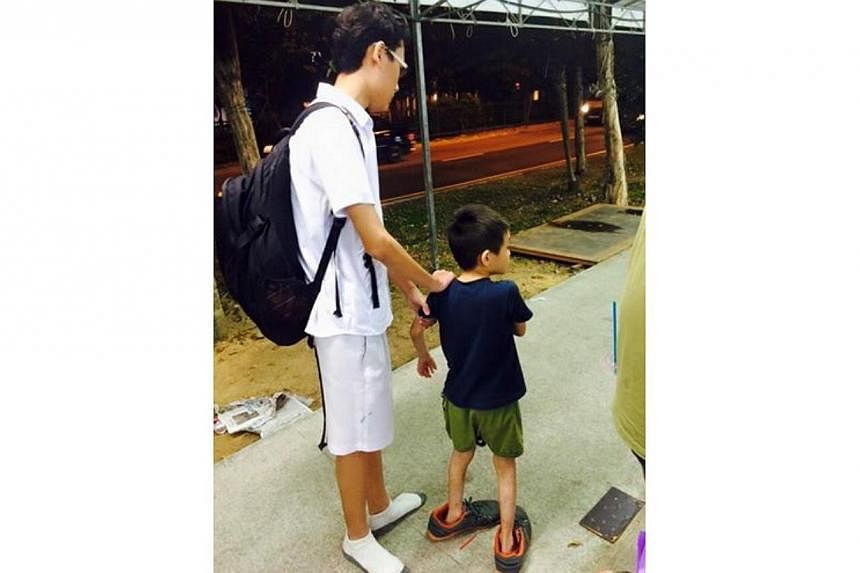 Facebook user Zen Ginji on Wednesday posted a photo of the boy in oversized shoes with a caption commending the student. He said the student is from Edgefield Secondary School in Punggol. -- PHOTO: ZEN GINJI/FACEBOOK