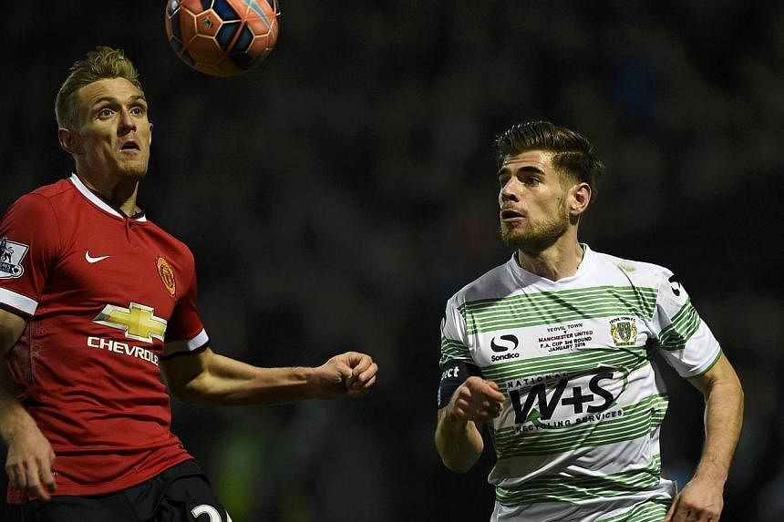Darren Fletcher of Manchester United (left) and Joseph Edwards of Yeovil chase the ball during their FA Cup third round soccer match at Huish Park, Yeovil, western England, Jan 4, 2015. -- PHOTO: REUTERS