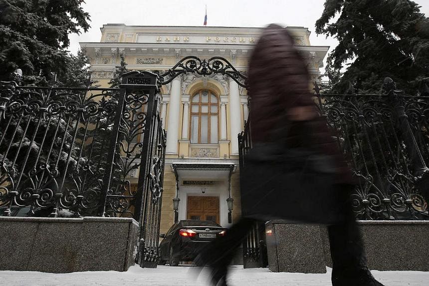 A pedestrian walks past the Central Bank headquarters in Moscow on Jan 30, 2015. Russia's central bank cut its key interest rate by two points to 15 percent on Friday, as the economy slides toward recession because of a collapse in global oil prices 