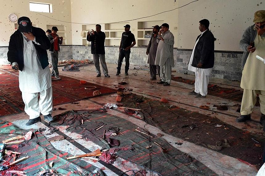 Pakistani security officials gather at a Shi'ite Muslim mosque after a bomb explosion in Shikarpur in Sindh province, around 470km north of Karachi on Jan 30, 2015. -- PHOTO: AFP