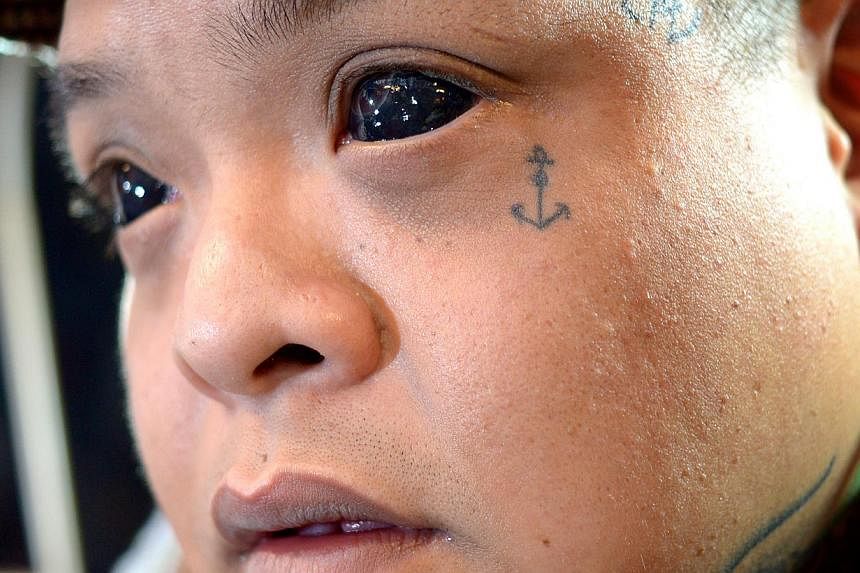 Tattoo artist Chester Lee, 28 has an eyeball tattoo done by American artist Luna Cobra. -- ST PHOTO: JAMIE KOH
