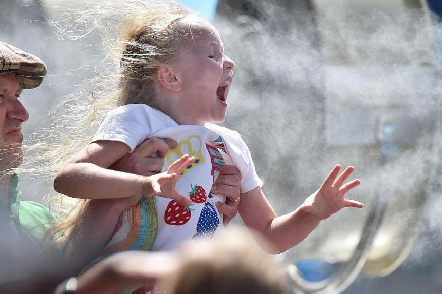 A child cooling off next to a fan at the 2015 Australian Open tennis tournament in Melbourne on Jan 19, 2015. PM Tony Abbott will unveil a new package of measures intended to improve childcare and support families in a speech on Feb 2, 2015, reported