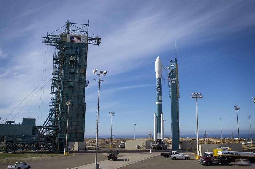 A handout picture made available by NASA on Jan 30, 2015 shows the United Launch Alliance Delta II rocket with the Soil Moisture Active Passive (SMAP) observatory onboard as the mobile service tower is moved back to help workers service the rocket at