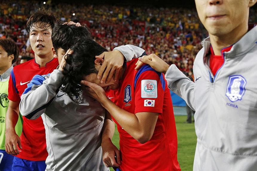 South Korea's Son Heung-min (centre) is consoled by team mates after their Asian Cup final soccer loss to Australia at the Stadium Australia in Sydney Jan 31, 2015. -- PHOTO: REUTERS