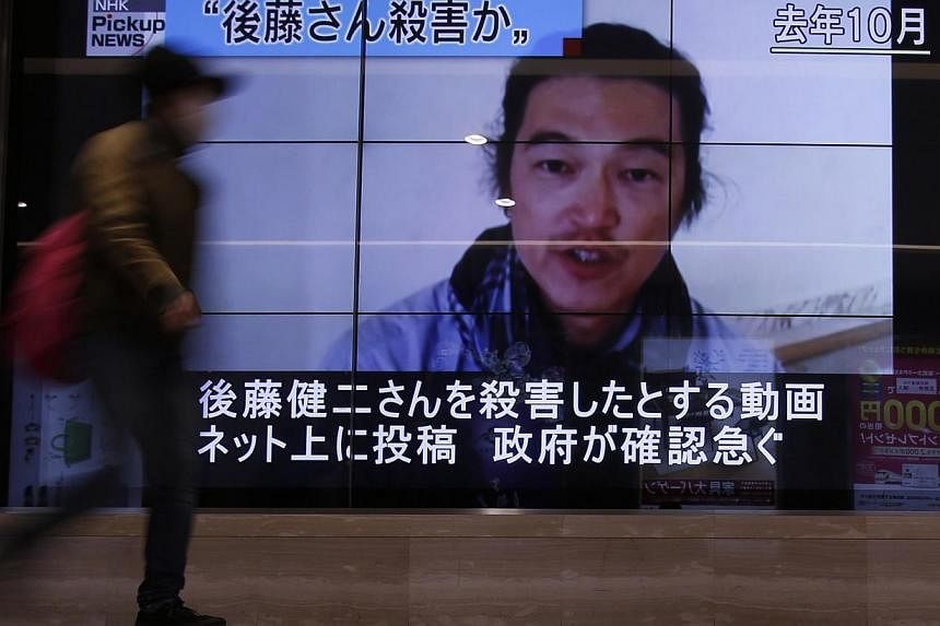 A pedestrian walks past television screens displaying a news programme about Japanese journalist Kenji Goto, who was a hostage of Islamic State in Iraq and Syria (ISIS) militants, on a street in Tokyo, on Feb 1, 2015.&nbsp;Singapore strongly condemns