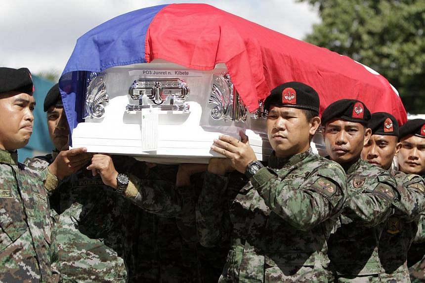 Members of the Philippines' = elite Police Special Action Force (SAF) carry one of the coffins of their forty-four comrades during the funeral at Camp Bagong Diwa in Taguig, south of Manila, Philippines on Jan 31, 2015.&nbsp;The Philippine interior m