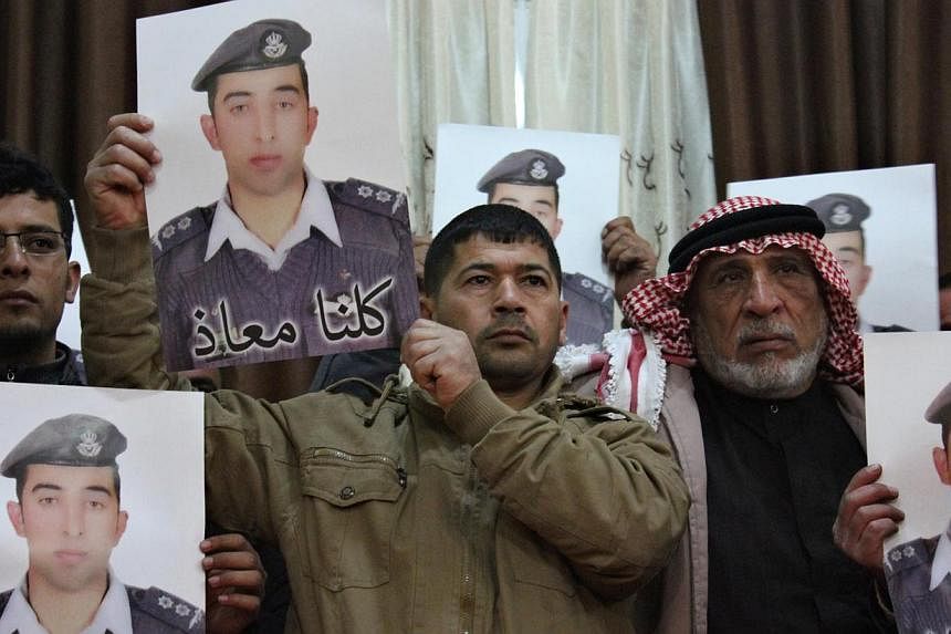 Relatives of Islamic State captive Jordanian pilot Muath al-Kasaesbeh hold his poster as they take part in a rally in his support at the family's headquarters in the city of Karak &nbsp;on Jan 31, 2015. -- PHOTO: REUTERS