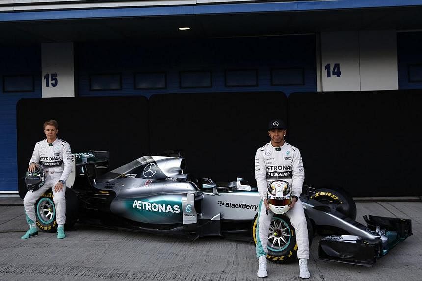 Mercedes Formula One racing drivers&nbsp;Nico Rosberg (left) of Germany and&nbsp;Lewis Hamilton (right) of Britain sit on the new Mercedes F1 M06 car during its official presentation on Feb 1, 2015.&nbsp;Rosberg vowed "maximum attack" in a new title 