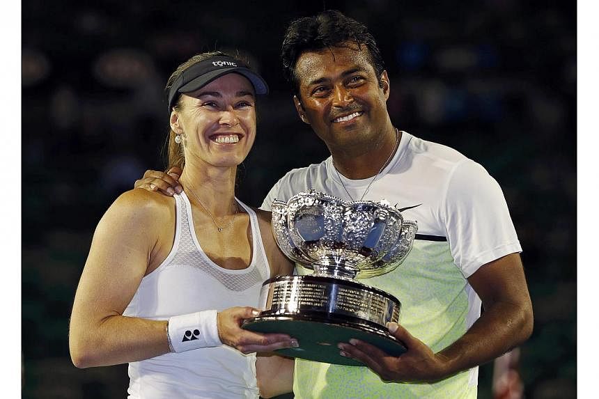 Martina Hingis (left) of Switzerland and Leander Paes of India pose with their trophy after defeating Kristina Mladenovic of France and Daniel Nestor of Canada to win their mixed doubles final match at the Australian Open 2015 tennis tournament in Me