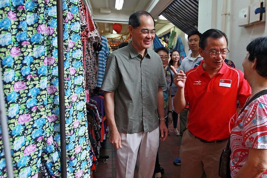 Minister for Trade and Industry Lim Hng Kiang (left) and&nbsp;Marine Parade GRC MP Seah Kian Peng (in red) speaking to a resident during a visit to Braddell Heights on Feb 1, 2015. -- PHOTO:&nbsp;LIANHE ZAOBAO&nbsp;