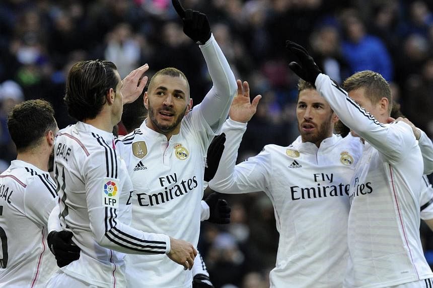 Real Madrid's French forward Karim Benzema (third left) celebrates with teammates after scoring during the Spanish league football match Real Madrid versus Real Sociedad de Futbol in Madrid on Jan 31, 2015. -- PHOTO: AFP&nbsp;