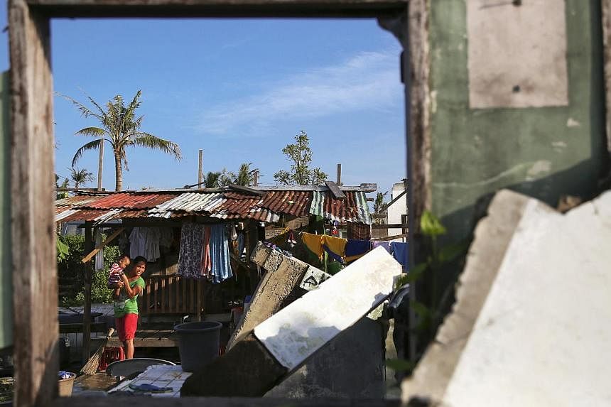 A resident of Tacloban walks with her child in part of the coastal area of the city that was destroyed by Typhoon Haiyan, on Jan 15, 2015. Australia is donating two decommissioned landing craft to the Philippine navy after the South-east Asian nation