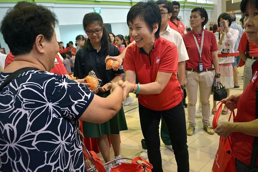 Minister in the Prime Minister's Office&nbsp;Grace Fu distributing goodie bags comprising two 1kg packets of rice, a packet of red dates, a packet of ginger tea and oatmeal, two mandarin oranges and ang pows to about 2,000 residents at the Yuhua Comm