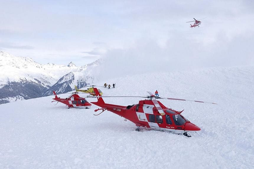 A haoudout picture taken and provided by the police of the Swiss Canton of Graubuenden on Saturday near Seewis, eastern Switzerland, shows Rescuers at the site of an avalanche that hit nine skiers on the Piz Vilan mountain at an altitude of some 2,20