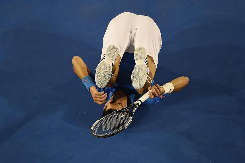Serbia's Novak Djokovic rolls on the court during his men's singles final match against Britain's Andy Murray at the 2015 Australian Open tennis tournament in Melbourne on Sunday.-- PHOTO: AFP