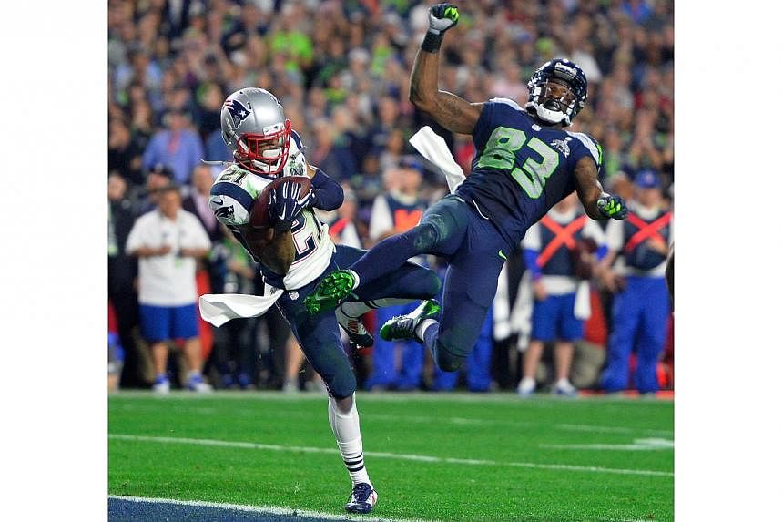 New England Patriots strong safety Malcolm Butler (left) makes an interception as he collides with Seattle Seahawks wide receiver Ricardo Lockette (right) during the final seconds of Super Bowl XLIX between the New England Patriots and the Seattle Se