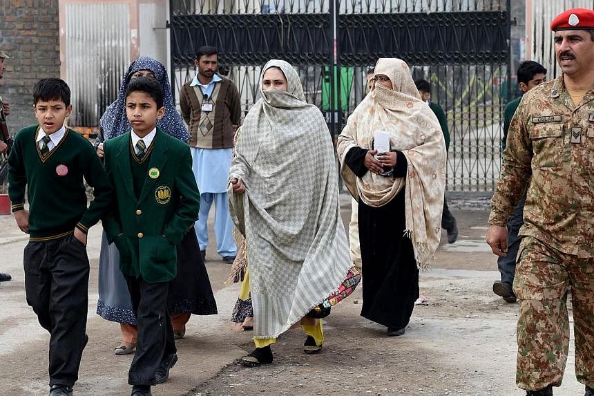 Pakistani parents leave the Army Public School with their children after it was reopened following an attack there by Taleban militants in Peshawar on Jan 12, 2015.&nbsp;A group of students and teachers who survived the massacre left for a trip to Ch