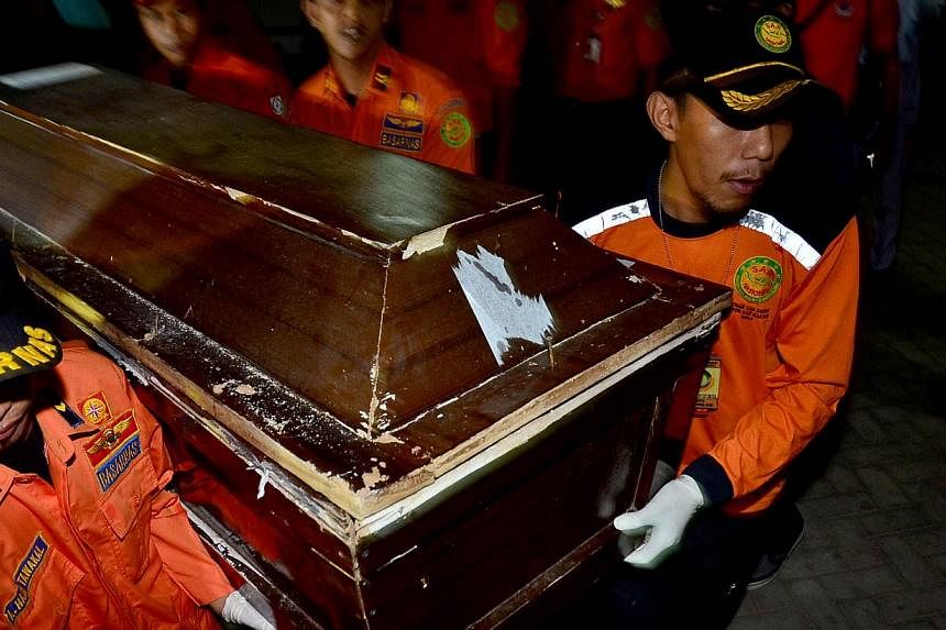 Members of an Indonesian rescue team carry a coffin with the remains of a victim of the AirAsia flight QZ8501 accident, in Makassar, South Sulawesi on Jan 30, 2014. The AirAsia flight QZ8501's emergency locator transmitter (ELT) has reportedly been f