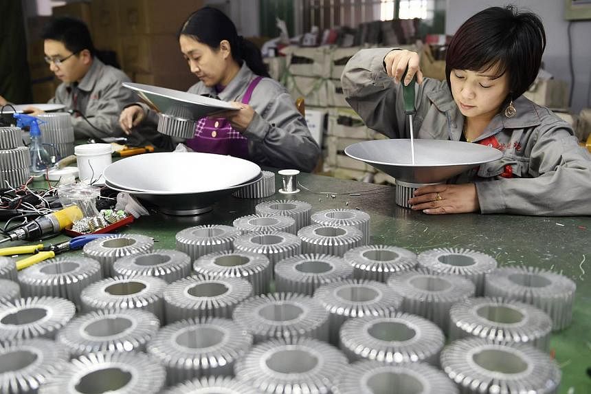 Workers assemble LED lights at a factory in Zouping, in eastern China's Shandong province. The risk of global deflation looms large for 2015 as surveys of China's mammoth manufacturing sector showed excess supply and deficient demand in January drove