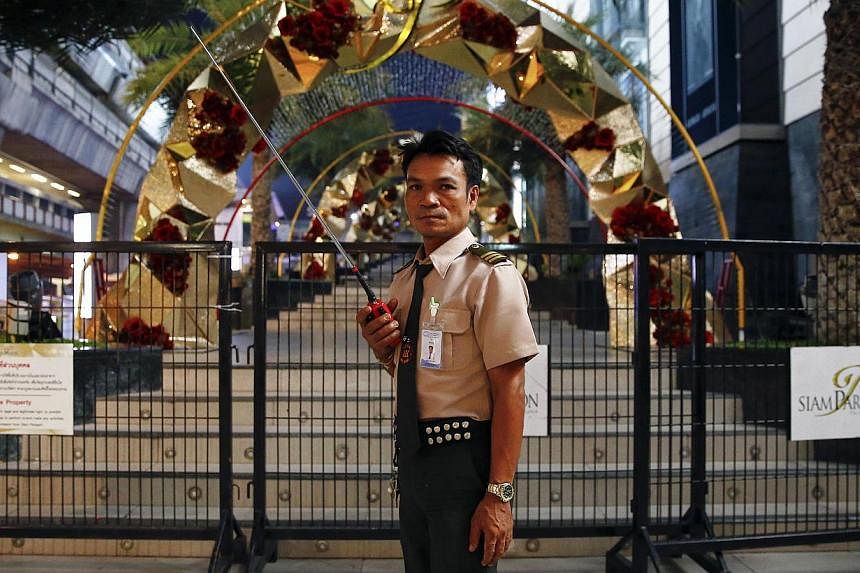 A guard secures the area around Siam Paragon mall in central Bangkok early this morning. Two pipe bombs exploded outside the luxury shopping mall in Bangkok on Sunday in an attack which Thai police said was aimed at raising tension in a city living u