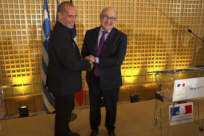 French Finance Minister Michel Sapin (right) and Greek Finance Minister Yanis Varoufakis arrive at a joint news conference after a meeting at the Bercy Finance Ministry in Paris on Sunday. -- PHOTO:&nbsp;REUTERS